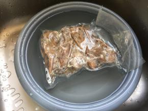 将鸭头隔着包装袋冷水解冻；