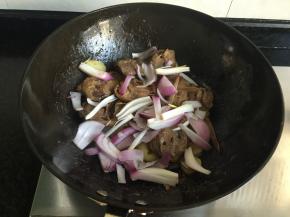 汤汁快干的时候撒入洋葱翻炒熟出锅，撒上适量葱花点缀即可；