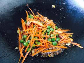 放入豌豆、胡萝卜、香菇翻炒均匀断生。