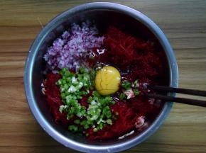 肉末中加入甜菜根丝、洋葱、葱末和燕麦片，加适量盐，再打入一个鸡蛋拌匀
