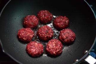 取肉馅做成肉饼，入煎锅中煎制