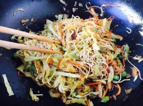 用筷子拌匀面和蔬菜。