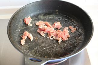炒锅下入色拉油，放入腌制后的肉片滑炒一下。