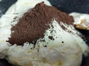 棉花糖融化后加入奶粉和可可粉，快速翻炒均匀。