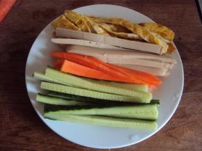 把摊好的薄薄的鸡蛋皮切条、胡萝卜、黄瓜、火腿肠全部切条