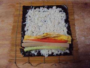 将备好的食材放在米饭的三分之一处