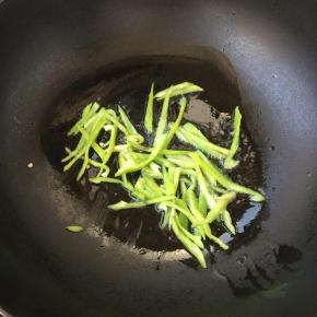 先把青椒丝放入翻炒断生，盛出备用