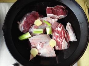 锅里添凉水，将牛肉放进去，葱和姜也一起放入锅中，打开火准备焯水去腥去血沫，