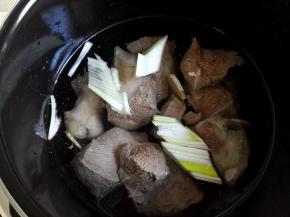 高压锅里加入适量清水，将牛肉放进去，再放适量的葱段和姜片，