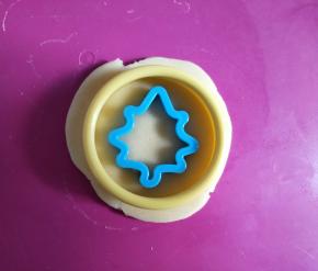 擀开成约4毫米的薄片，用圆形模具按出圆形饼干，再用小模具按出中间的图案。