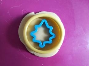 擀开成约4毫米的薄片，用圆形模具按出圆形饼干，再用小模具按出中间的图案。