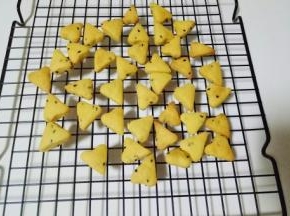 戴上隔热手套取出烤盘，把饼干小心的倒在烤网上晾凉。