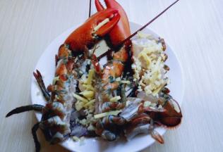 将清洗干净的大龙虾摆放在盘子里，(龙虾肉还是放回尾部里呦。)均匀撒上姜末和蒜末。