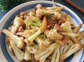 将调味料翻炒均匀，临出锅前加点葱花，花菜炒熟就可以出锅了。