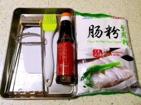首先必须要有一套做肠粉的工具，托盘一个，刮板一块，油刷一把，取盘夹一个。