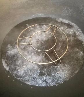 锅里放个蒸架，倒入比蒸架矮一点的清水，烧开。