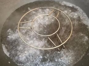 锅里放个蒸架，倒入比蒸架矮一点的清水，烧开。