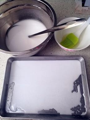 盛两勺肠粉水到刷了油的托盘上，保证肠粉水能薄薄的铺平在托盘里的量就行。每次盛之前要将肠粉水充分搅匀，因为静置的肠粉水非常容易分层。