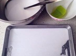盛两勺肠粉水到刷了油的托盘上，保证肠粉水能薄薄的铺平在托盘里的量就行。每次盛之前要将肠粉水充分搅匀，因为静置的肠粉水非常容易分层。