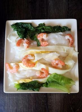 用刮板切几下鸡蛋，把配菜放在肠粉上。