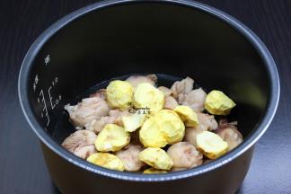把鸡腿放入电饭锅底，接着放生姜、栗子，倒入一点点水，按煮饭键；