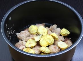 把鸡腿放入电饭锅底，接着放生姜、栗子，倒入一点点水，按煮饭键；