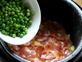 10.电锅跳了以后，揭开盖，将速冻豌豆倒入锅中。
