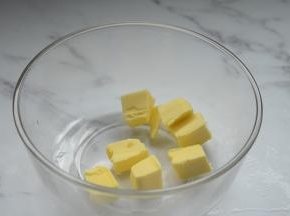 黄油切小块放入容器里
