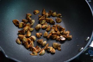 锅中倒油烧热，放入蘑菇煎煸至金黄