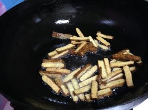 原锅再加入少量的油，倒入香干煎至表面起痂捞出备用