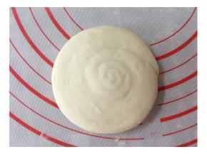 再压扁成圆形馍坯，盖上湿毛巾或油纸醒发10分钟。