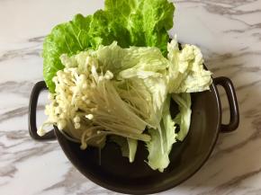 在砂锅里，一层一层码上蔬菜和金针菇。