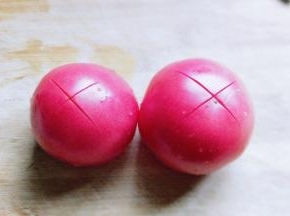 首先将番茄洗干净，再顶端用刀划出十字刀。