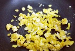 待鸡蛋饼表面凝固时再把它切碎，盛出备用。(用铲子切即可)