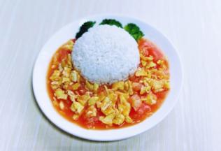 将熟米饭装入碗中，用铲子压实，之后倒扣再盘子里，如图。再把炒好的番茄炒蛋浇再上面，我还装饰了几朵焯水的西蓝花。