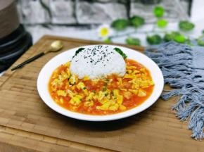 米饭上撒上少许熟黑芝麻，番茄炒蛋上撒少许葱花点缀。