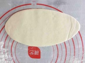 将醒发好的小面团压扁擀成长椭圆形。