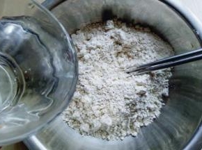 首先将莜面放入大口的器具中。分次加入开水。（切记不要一下子将开水倒入，不同的面粉吸水性不同，一定要分次加入开水）
