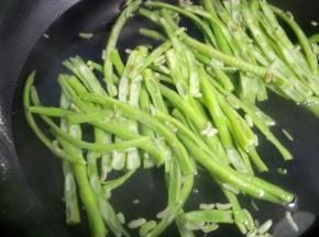 锅中烧热水，加少许盐下入豆角焯烫半分钟捞起备用。