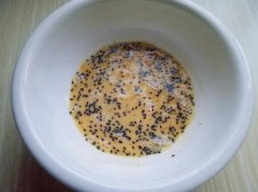 将鸡蛋敲再大口碗里，用筷子将鸡蛋打散。加入熟黑芝麻。(白芝麻也是可以的)用筷子搅拌均匀。