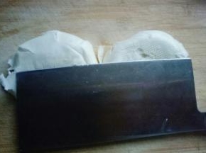 一个大白馒头，用刀身将其压扁。再次用刀身压切好的馒头片。将压扁的馒头丁切块。