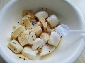 把切好的馒头丁放入蛋液中。加入盐，用筷子翻拌均匀。