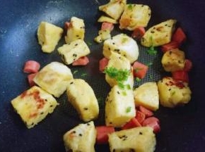 煎好的馒头丁撒上切好的葱花。