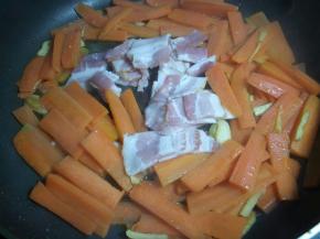 把培根下入锅中煎。