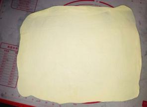 案板上抹油，把饼皮擀成长方形