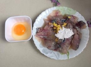 罗非鱼鱼肉切连刀成鱼片，加入半个蛋清，生粉和盐，姜末腌制十分钟。