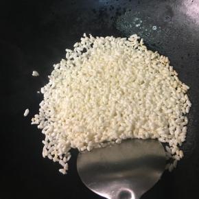 锅里放烧热放入阴米炸成米花。