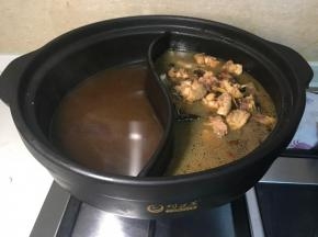 把鸡肉和油茶水分别倒入鸳鸯锅里。