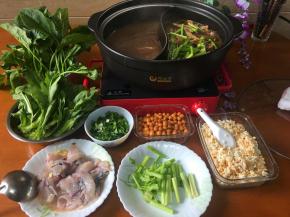 所有的火锅料端上桌， 鸳鸯锅也端到电陶炉开火继续烹煮。