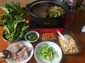 所有的火锅料端上桌， 鸳鸯锅也端到电陶炉开火继续烹煮。